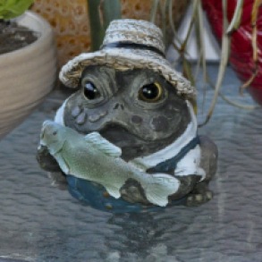 Close up of Frog statute holding a fish.g